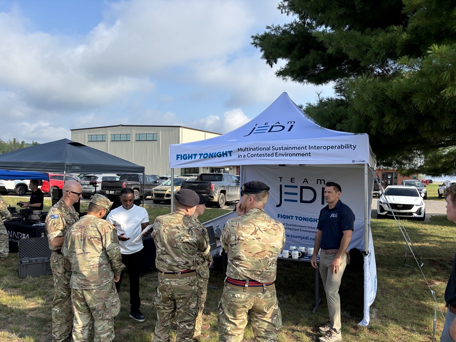 Team JEDI briefing multinational service members under the Team JEDI tent at Northern Strike 26
